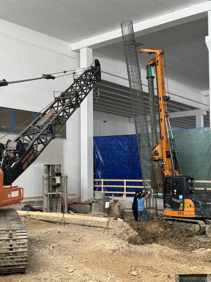 Calata di una gabbia d'armatura con operatori in cantiere