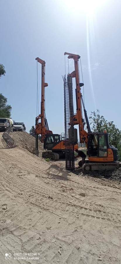 Due perforatrici in sollevamento di una gabbia d'armatura su pendio