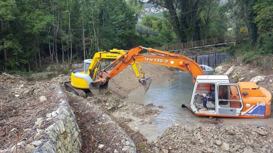 Due escavatori al lavoro in un alveo fluviale