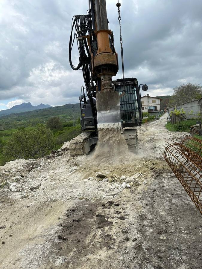 Perforatrice che scarica terra dalla coclea su un percorso di cantiere