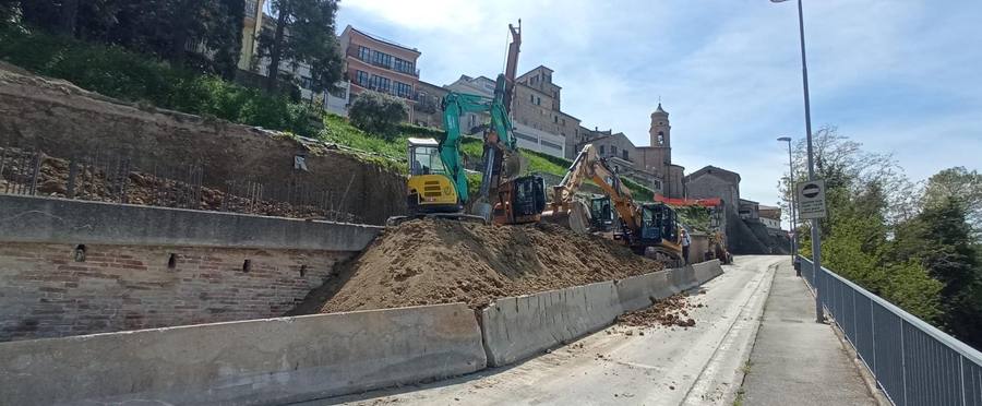 Escavatori al lavoro dietro barriere New Jersey su strada